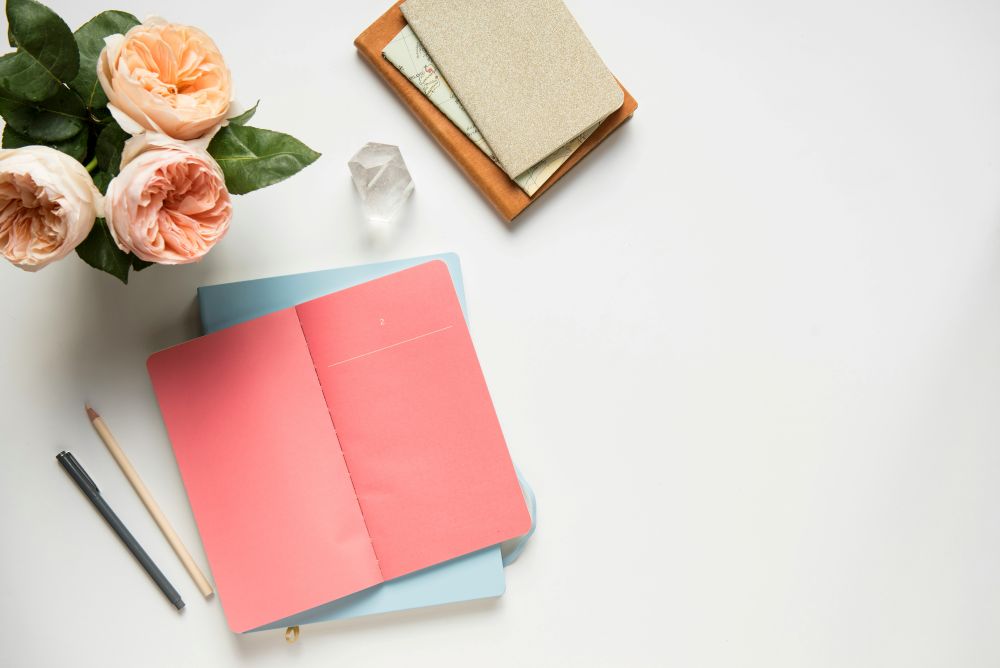 Notizbücher auf einem Tisch mit Blumen